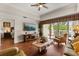 Inviting living room with a ceiling fan, hardwood floors, and sliding glass doors to a balcony at 7660 Whisper Way # 402, Reunion, FL 34747