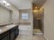 En suite bathroom featuring a soaking tub, a separate shower, and a dark vanity at 7806 Tanbier Dr, Orlando, FL 32818