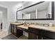 Elegant bathroom with dual granite countertop vanities, dark cabinets, and a well-lit, large mirror at 8122 Roseville Rd, Davenport, FL 33896