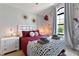 Charming bedroom featuring a cozy red bed, a TV, and unique decorative wall art at 8122 Roseville Rd, Davenport, FL 33896