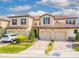 Inviting Mediterranean-style townhome featuring a tile roof and well-manicured landscaping at 8122 Roseville Rd, Davenport, FL 33896