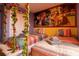 Cozy bedroom with two beds, Encanto-themed mural and playful hanging swing chairs, perfect for  at 8124 Roseville Rd, Davenport, FL 33896