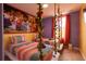 Bright bedroom with colorful bedding, floral accents and a playful Encanto-themed mural for a whimsical touch at 8124 Roseville Rd, Davenport, FL 33896