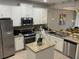 Well-equipped kitchen with stainless steel appliances, granite countertops, and a center island for ample workspace at 8124 Roseville Rd, Davenport, FL 33896