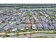 A wide aerial shot of houses in a well-planned neighborhood near a serene lake, perfect for families and nature lovers at 8226 Nemours Pkwy, Orlando, FL 32827