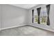 Bedroom featuring neutral walls, carpeted floor, and two windows with curtains at 8226 Nemours Pkwy, Orlando, FL 32827
