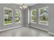 Bright dining room featuring tile floors, modern chandelier, and three large windows at 8226 Nemours Pkwy, Orlando, FL 32827