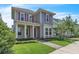 Charming two-story home with pink shutters, a covered front porch, and a well-maintained lawn at 8226 Nemours Pkwy, Orlando, FL 32827