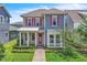 Charming two-story home featuring pink shutters, a covered front porch, and manicured landscaping at 8226 Nemours Pkwy, Orlando, FL 32827