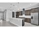 Modern kitchen with an island, dark cabinets, stainless steel appliances, and tile flooring, offering a sleek design at 8226 Nemours Pkwy, Orlando, FL 32827