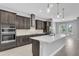 Modern kitchen with dark cabinets, a large island, stainless steel appliances, and subway tile backsplash at 8226 Nemours Pkwy, Orlando, FL 32827