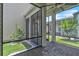 The screened lanai has brick floors, white trim and support columns and an inviting view of the outdoors at 8226 Nemours Pkwy, Orlando, FL 32827