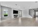Bright living room with a modern fireplace, large windows, and stylish wood-look tile flooring at 8226 Nemours Pkwy, Orlando, FL 32827