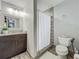 Well-lit bathroom featuring a vanity, shower with a curtain, and a toilet at 8606 Port Said St, Orlando, FL 32817