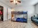 Bright bedroom features wood-look tile, bunk beds, closet space and comfortable seating at 8606 Port Said St, Orlando, FL 32817