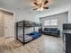 Well-lit bedroom with wood-look tile flooring, comfortable seating, and a functional bunk bed at 8606 Port Said St, Orlando, FL 32817