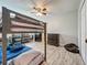 Spacious bedroom with a bunk bed, wood-look tile flooring, and a cozy seating area at 8606 Port Said St, Orlando, FL 32817