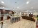 Open kitchen with an island featuring barstool seating, flowing into the living area with wood-look flooring at 8606 Port Said St, Orlando, FL 32817