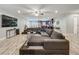 Spacious living room with wood-look floors, a large sectional couch, and an open view into the kitchen at 8606 Port Said St, Orlando, FL 32817