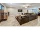 Open-concept living room featuring wood-look flooring, large sectional couch and mounted television at 8606 Port Said St, Orlando, FL 32817