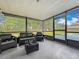 A screened porch offers outdoor seating and views of the expansive backyard at 8606 Port Said St, Orlando, FL 32817