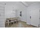 Dining room with seating for eight, featuring white wooden chairs, a chandelier, and wood-look tile flooring at 1123 Dora Parc Ln, Mount Dora, FL 32757
