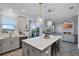 Bright, modern kitchen with gray cabinetry, quartz countertops, and stainless steel appliances, with pendant lighting over the island at 1123 Dora Parc Ln, Mount Dora, FL 32757