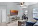 Cozy living room featuring neutral walls, ceiling fan, tv and view into an exercise space at 1123 Dora Parc Ln, Mount Dora, FL 32757