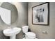 Tasteful powder room featuring a pedestal sink, round mirror, textured wallpaper, and modern artwork at 11360 Blue Bay Dr, Orlando, FL 32832