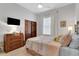Comfortable bedroom featuring a ceiling fan, dresser, wooden doors, and a window at 1166 Adair Park Pl, Orlando, FL 32804