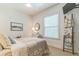 Bright bedroom with a large window, dresser, television, and a decorative quilt ladder at 1166 Adair Park Pl, Orlando, FL 32804