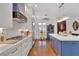 Chef's kitchen featuring white cabinetry, a blue island, and hardwood floors at 1166 Adair Park Pl, Orlando, FL 32804