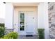 Front door entrance with sidelight featuring stone accents and manicured landscaping at 1311 Arisha Dr, Kissimmee, FL 34746