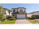 Charming two-story home with a brick driveway, featuring a two-car garage and manicured landscaping at 1311 Arisha Dr, Kissimmee, FL 34746