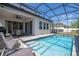 Beautiful screened-in pool area with a seating area, lounge chairs, and inviting pool steps at 1311 Arisha Dr, Kissimmee, FL 34746