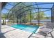 Relaxing screened-in pool area with lounge chairs and lush backyard greenery at 1311 Arisha Dr, Kissimmee, FL 34746