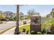 View down the street showcasing the neighborhood entrance, palm trees and well-maintained landscaping at 1311 Arisha Dr, Kissimmee, FL 34746