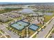 Beautiful aerial view of the community tennis and basketball courts, set against the backdrop of a serene lake and lush landscapes at 13462 Panama Beach Ct, Orlando, FL 32827