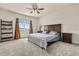 Well-lit bedroom features a ceiling fan, large bed, and view to the neighborhood at 13462 Panama Beach Ct, Orlando, FL 32827