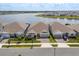 Lovely aerial view of three modern homes in a lakeside community with manicured lawns, charming details, and ample parking at 13462 Panama Beach Ct, Orlando, FL 32827