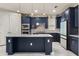Gourmet kitchen boasts stylish navy blue cabinets and stainless steel appliances at 13462 Panama Beach Ct, Orlando, FL 32827