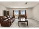 Cozy living room with comfortable leather seating, plush carpet, and a lake view at 13462 Panama Beach Ct, Orlando, FL 32827