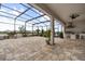 Expansive screened patio with brick flooring, outdoor kitchen, ceiling fan, and scenic lake views, perfect for entertaining at 13462 Panama Beach Ct, Orlando, FL 32827