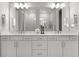Bright bathroom featuring a double sink vanity with a large mirror and modern fixtures at 13758 Tybee Beach Ln, Orlando, FL 32827