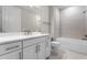 Beautiful bathroom with dual sinks, white cabinets, and tub with shower at 13758 Tybee Beach Ln, Orlando, FL 32827