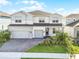 Beautiful two-story home with a three-car garage, brick driveway, and manicured landscaping at 13758 Tybee Beach Ln, Orlando, FL 32827