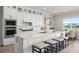 Modern kitchen with white cabinetry, large island with seating, and stainless steel appliances at 13758 Tybee Beach Ln, Orlando, FL 32827