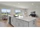 Open-concept kitchen island connects to dining area with views of a relaxing backyard pond at 13758 Tybee Beach Ln, Orlando, FL 32827