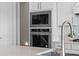 Modern kitchen showcasing stainless steel built in microwave and oven with sleek white cabinetry at 13758 Tybee Beach Ln, Orlando, FL 32827
