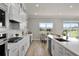 Open-concept kitchen includes white countertops, stainless appliances, and views of the neighborhood pond at 13758 Tybee Beach Ln, Orlando, FL 32827